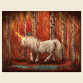 A fantasy art print depicting a white unicorn with a glowing golden horn walking through an autumn birch forest with a small blue pond and a blue bird on its neck, shown against a light beige background.